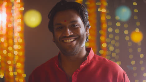 Portrait-Of-Smiling-Asian-Man-Celebrating-Diwali-Against-Bokeh-Lighting-Background